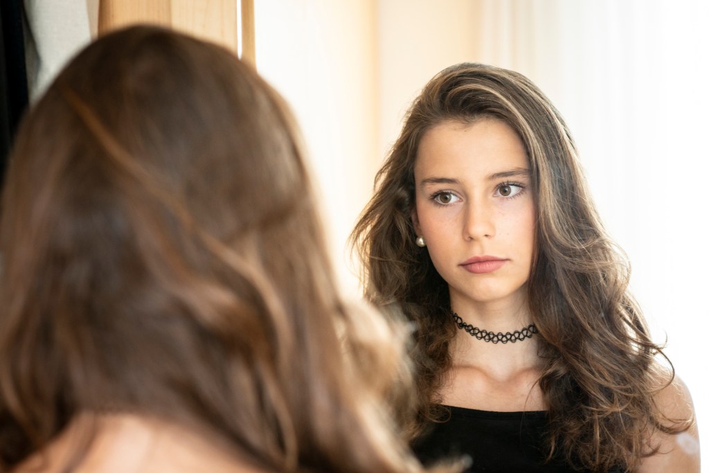 Teenager-Mädchen vor dem Spiegel.