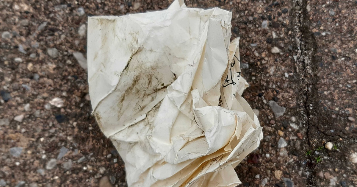 Ein zerknülltes Blatt Papier, das auf einer Straße liegt.