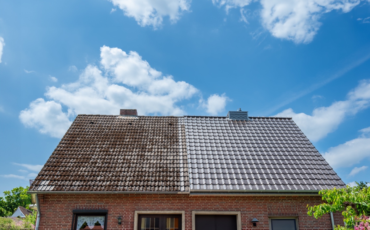 Ein Dach von einem Haus, das zur Hälfte gereinigt wurde.