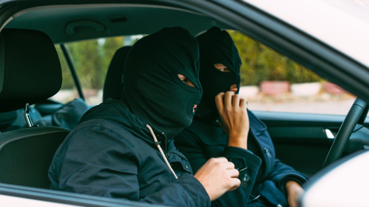 Gangster, die ihre Maske aufsetzen und sich auf den nächsten Raubüberfall vorbereiten.