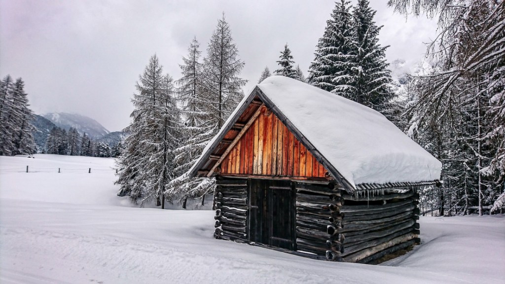 Ein Foto von einer verschneiten Berghütte.