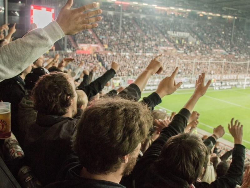 Jubelnde Fußballfans bei einem Fußballspiel im Stadium.