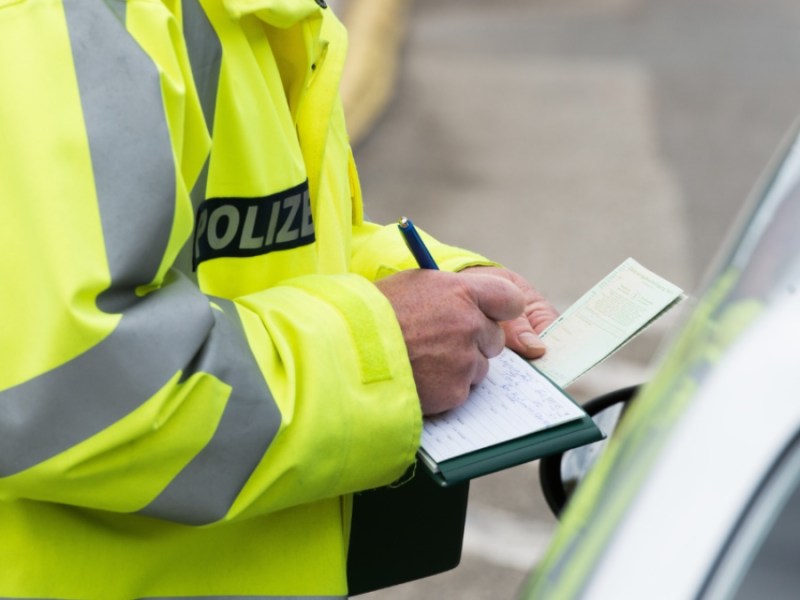 Ein Polizist schreibt ein Knöllchen.