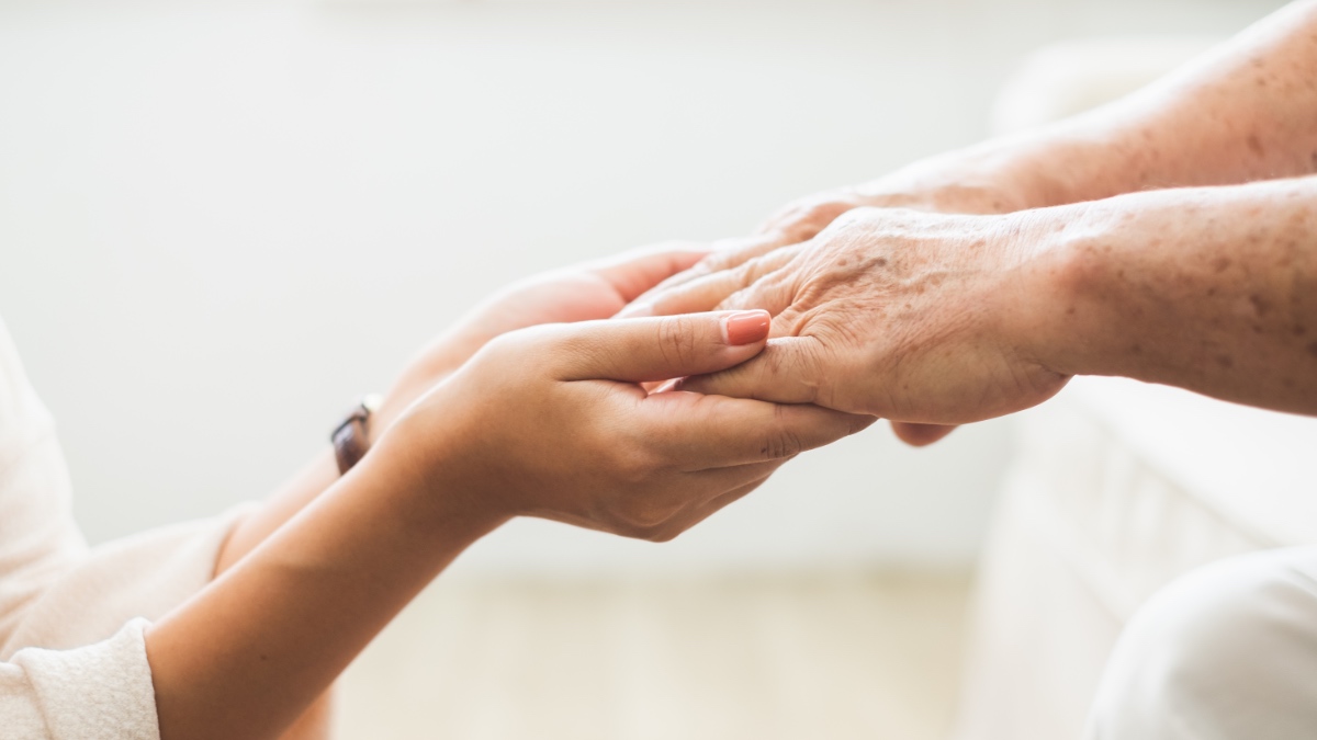 Junge Hand hält Hand von Rentner.